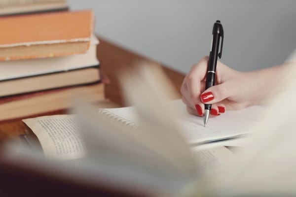 Teacher marking written essays at a desk